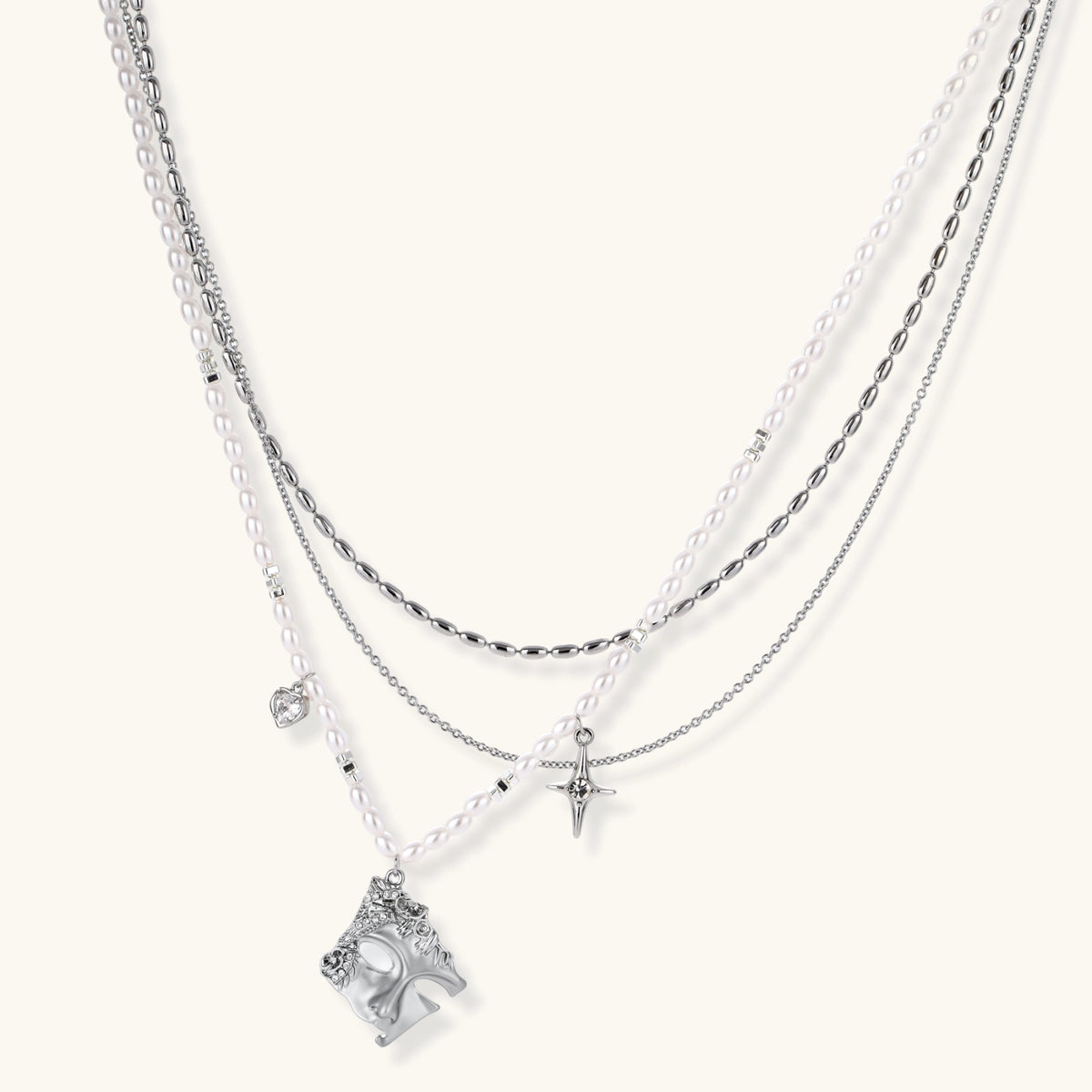 Multi-strand layered necklace set with silver chains, white pearls, star charm, heart pendant, and ornate decorative piece