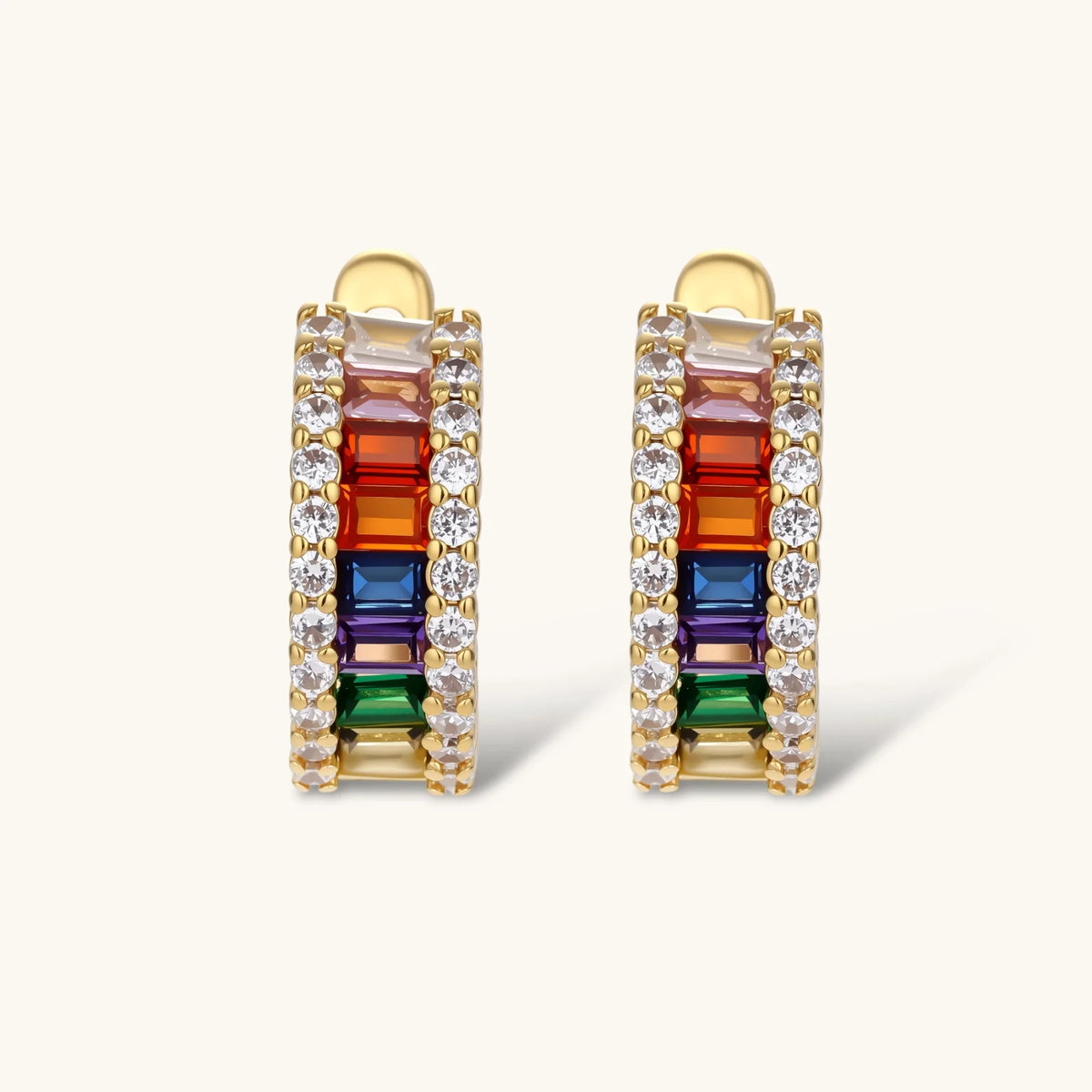 Gold-plated jewelry set featuring rainbow baguette-cut cubic zirconia stones in geometric design on cream background