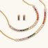 Gold-plated jewelry set featuring rainbow baguette-cut cubic zirconia stones in geometric design on cream background