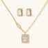 Gold-plated jewelry set with rectangular cubic zirconia stones in pave halo settings on cream background