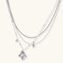 Multi-strand layered necklace set with silver chains, white pearls, star charm, heart pendant, and ornate decorative piece