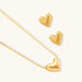Dainty 18K gold-plated sterling silver necklace with small heart pendant on delicate chain against cream background.