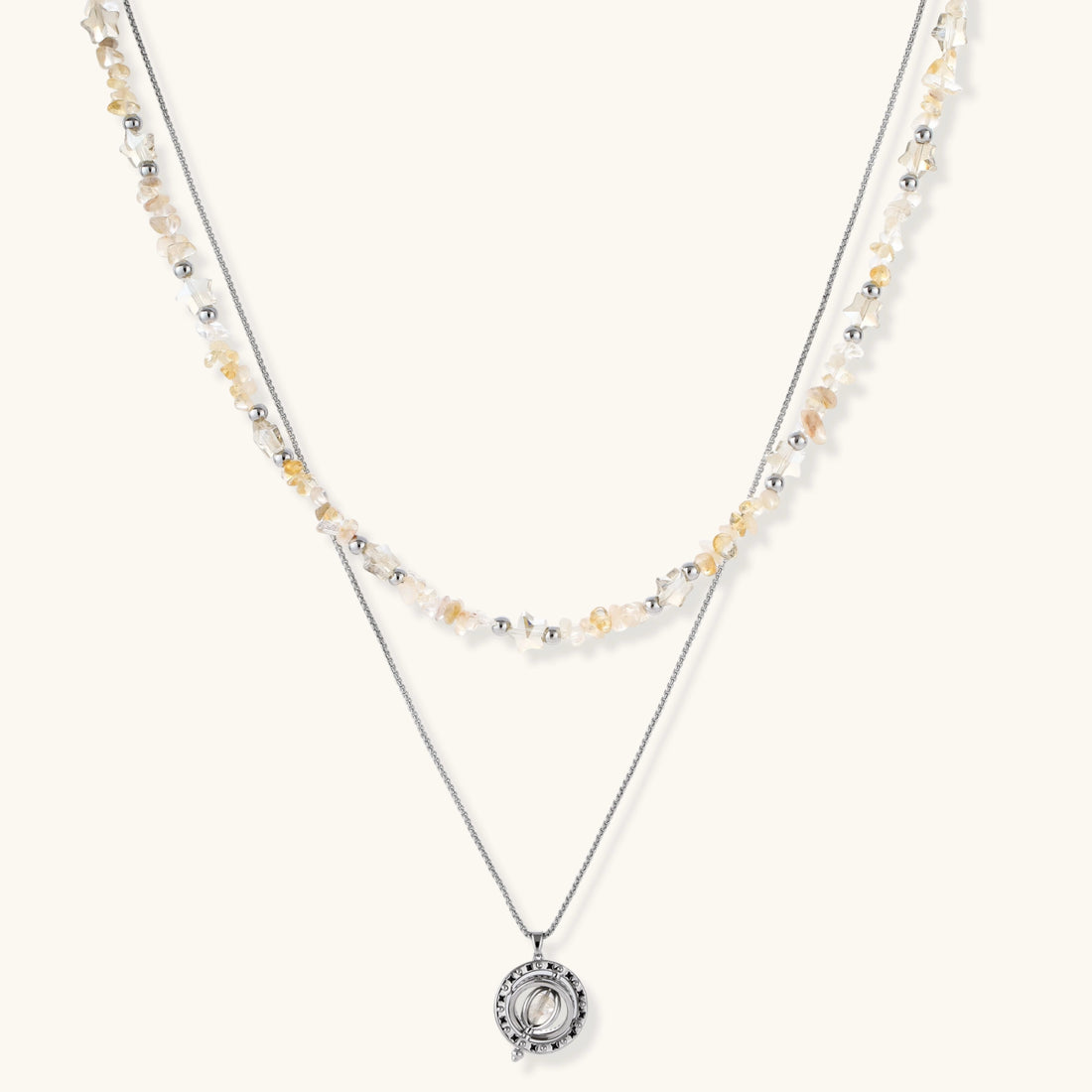 Two-layer necklace with natural stone chips and eco-brass beads, featuring a circular wrapped pendant on cream background.