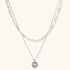 Two-layer necklace with natural stone chips and eco-brass beads, featuring a circular wrapped pendant on cream background.