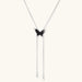 Wooden butterfly pendant necklace with cascading silver-toned chains on adjustable chain, available in amber and black.