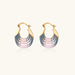 Gold hoop earrings with gradient blue-to-pink enamel in ribbed fan design on beige background
