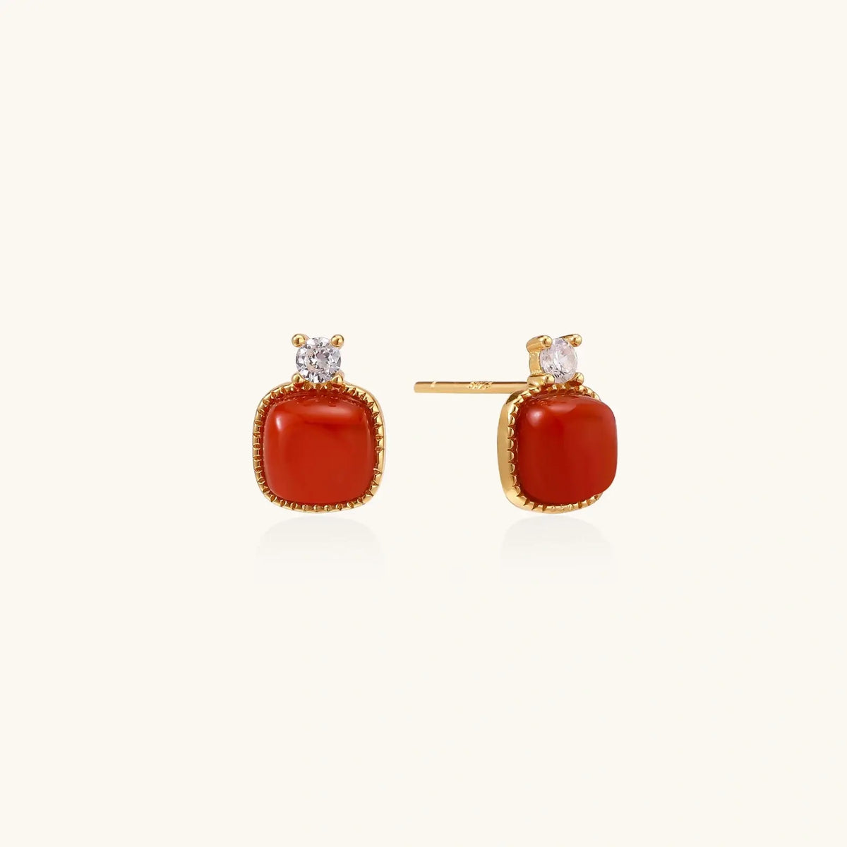 18K gold vermeil stud earrings with cushion-cut red agate stones and sparkling crystal accents on beige background