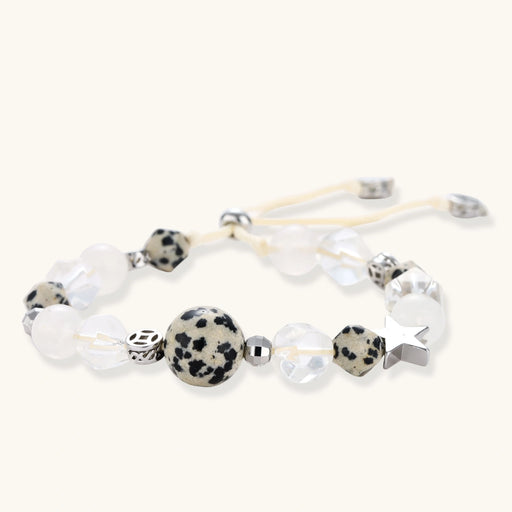 Adjustable beaded bracelet with spotted dalmatian stones, clear quartz crystals, and silver star charm on white background.