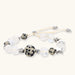 Adjustable beaded bracelet with spotted dalmatian stones, clear quartz crystals, and silver star charm on white background.