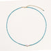 Delicate gold vermeil necklace with teal apatite beads and freshwater pearl on white background.