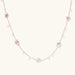 Gold vermeil chain with iridescent star-shaped baroque pearls and small round freshwater pearl drops on cream background.