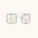 Rhodium-plated silver stud earrings with cushion frame, centered freshwater pearl, and tiny crystal accent
