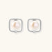 Rhodium-plated silver stud earrings with cushion frame, centered freshwater pearl, and tiny crystal accent
