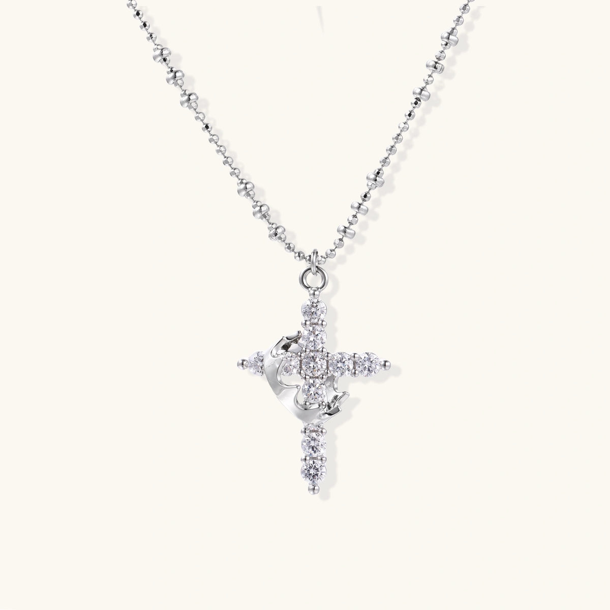 White gold-plated cross pendant adorned with sparkling zirconia stones and crescent moon accent on ball chain
