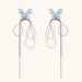 Long silver-tone earrings with powder blue enamel butterfly studs and flowing chain tassels on cream background