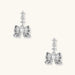 White gold plated drop earrings with three graduated zirconia crystals leading to a bow charm with pearl center