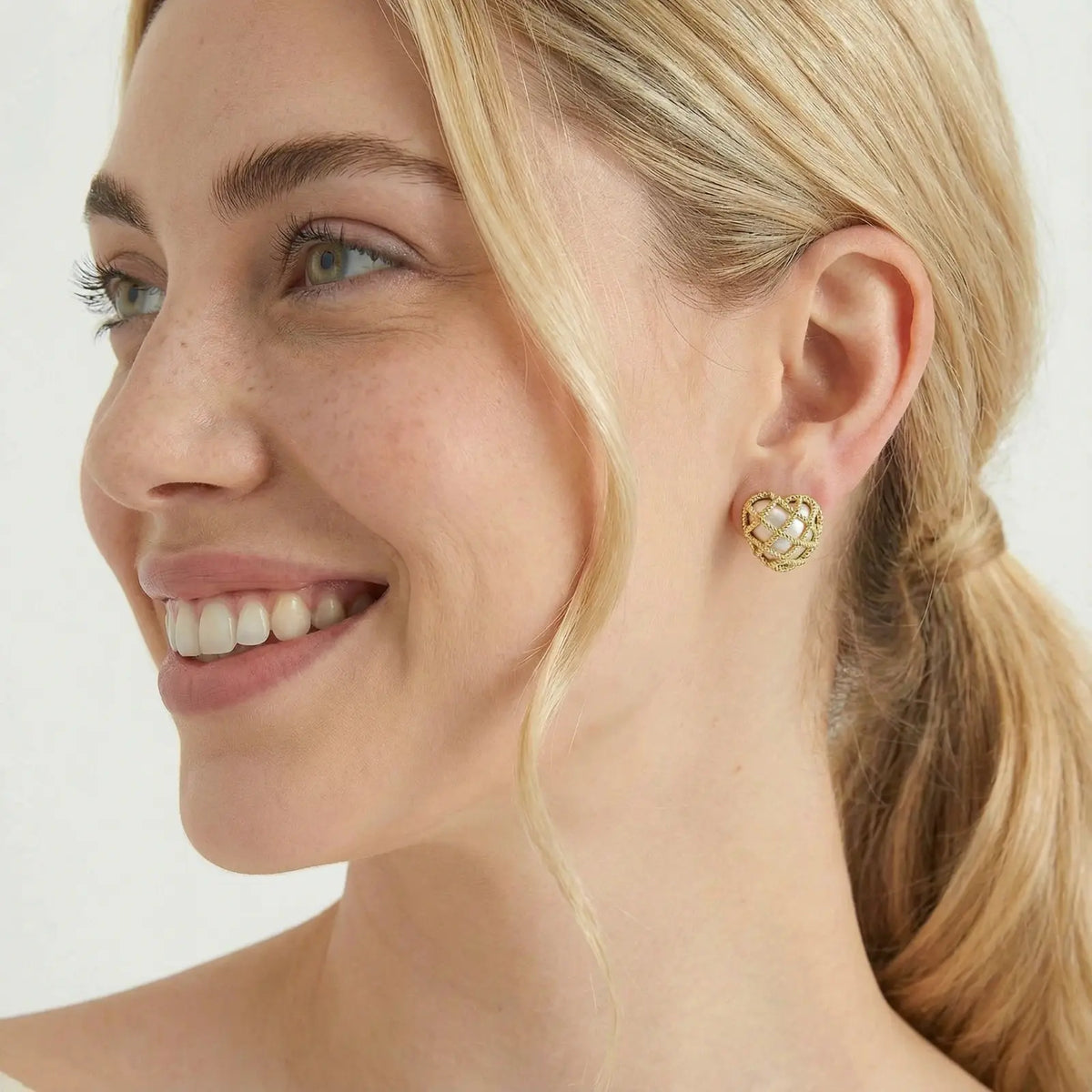 Model wearing gold plated geometric lattice stud earrings