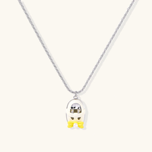 Chrome egg-shaped pendant with kawaii face, yellow bow, and pearl detail on silver chain against white background