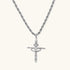 Silver-tone necklace with dimensional orb pendant, cross crown detail, and zirconia stones on twisted rope chain