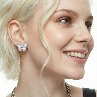 Model wearing white gold butterfly stud earrings with crystals