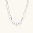 Sterling silver multi-strand necklace with three brushed round beads on cream background