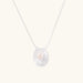Sterling silver disc necklace with textured finish and centered freshwater pearl on delicate chain