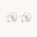 Brushed sterling silver half-dome clip-on earrings with textured surface against cream background