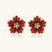 Gold-plated flower studs with burgundy square crystals in petal mosaic and clear center stones on beige background.
