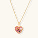 Heart-shaped pendant with pink enamel, rose design, freshwater pearl flower, and gold scalloped frame on delicate chain