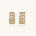 Gold-plated geometric hoop earrings with basket-weave lattice design and pavé crystal accents on cream background