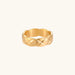 Close-up of an 18K gold-plated twisted band ring with dimensional braided pattern on cream background.