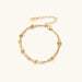 Three-strand gold-plated bracelet with clustered ball beads and adjustable clasp on cream background