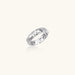 White gold adjustable ring with geometric triangle cutouts and zirconia stones on cream background