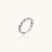White gold plated ring with architectural lattice design and zirconia accents on cream background