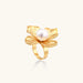 Gold-plated flower ring with textured petals and white cotton pearl center on cream background