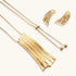 Gold-toned cascade jewelry set with flowing textured strands, featuring drop earrings and matching pendant necklace