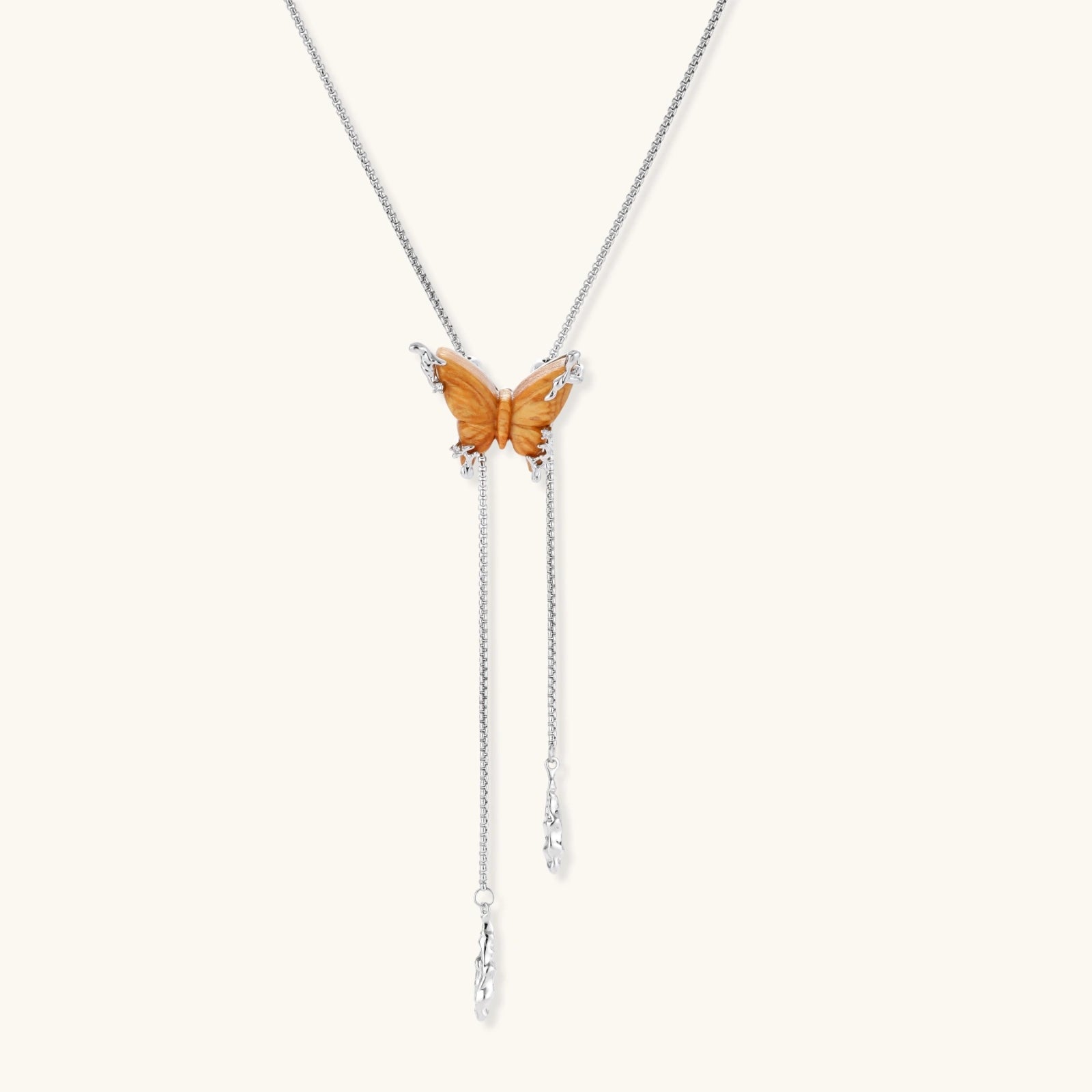 Delicate amber butterfly pendant with zirconia accents and cascading silver-toned chains on adjustable necklace.